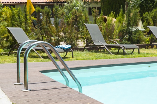 Piscina del Hotel Rural El Refugio Gran Canaria, con tumbonas y sombrilla, ideal para relajarse al sol.