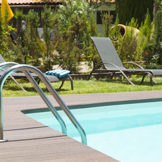 Piscina del Hotel Rural El Refugio Gran Canaria, con tumbonas y sombrilla, ideal para relajarse al sol.